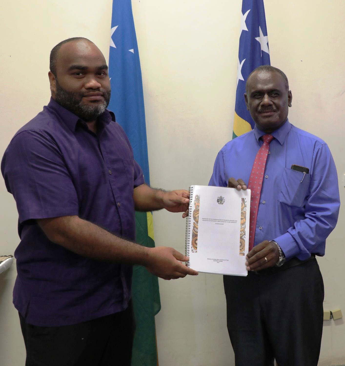 Minister Jeremiah Manele (right) and former Chief of Protocol Mr Kereta Sanga displays the handbook at the launching ceremony