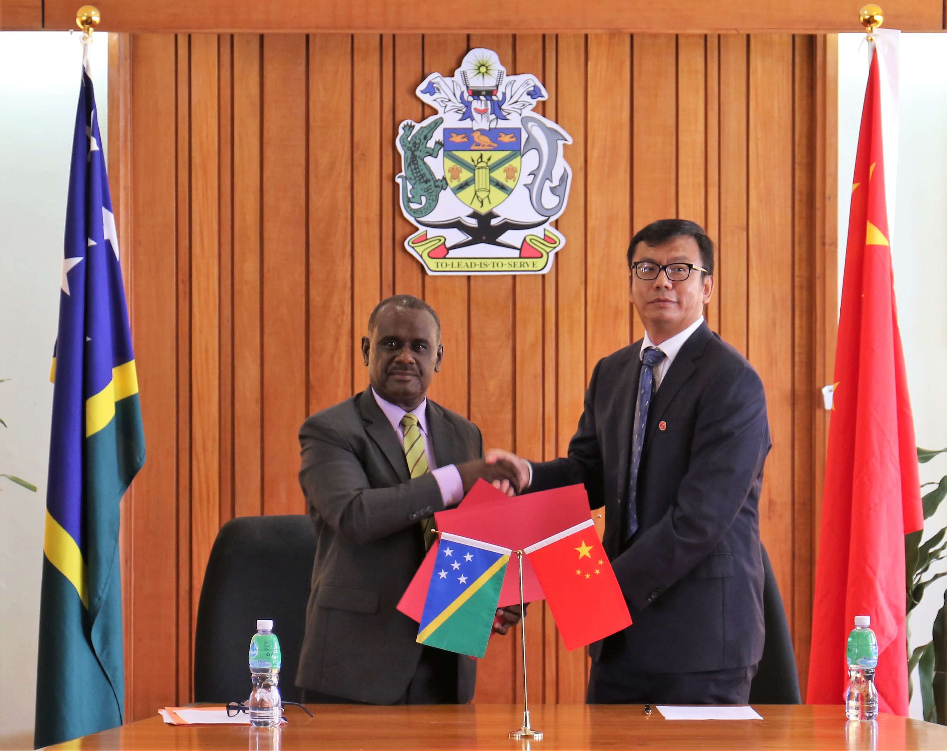 Minister Manele and PRC Chargé D'affaires Yao Ming exchanging of notes after the signing ceremony.