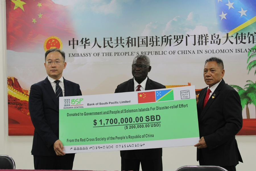 PRC Ambassador to the Solomon Islands, His Excellency, Mr. Li Ming presents a donation of $1.7m to the Supervising Minister of Foreign Affairs and External Trade, Hon. Peter Shanel Agovaka for disaster relief efforts in the country following the recent earthquake. Witnessing the occasion is the Prime Minister, Hon. Manasseh Sogavare.