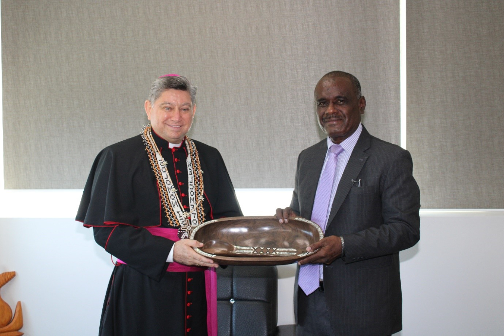 Apostolic Nuncio of the Holy See to the Solomon Islands, His Excellency Fremin Emilio Sosa Rodriguez being presented with a gift by the Minister of Foreign Affairs and External Trade, Hon. Jeremiah Manele